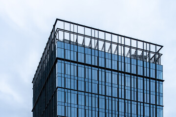 Modern office skyscraper with glass facade and rooftop structure