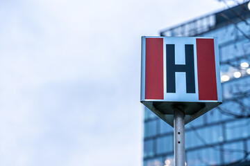 Red fire hydrant sign against office building and sky background
