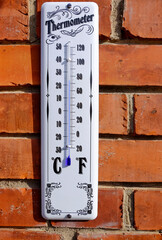 Ancient thermometer on a brick wall