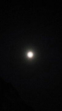 Shining bright moon in the dark night sky.