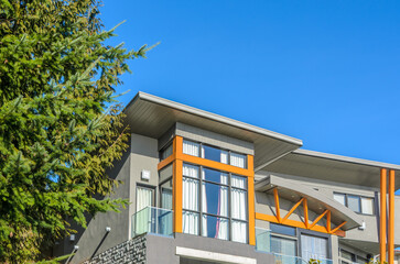 Top of luxury house with shingle roof, red and yellow trees and nice windows in Summer in...