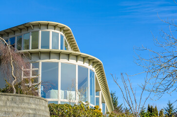 Top of luxury house with shingle roof, red and yellow trees and nice windows in Summer in...