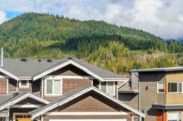 Top of luxury house with shingle roof, red and yellow trees and nice windows in Summer in...