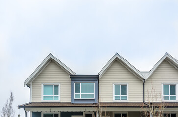 Top of luxury house with shingle roof, red and yellow trees and nice windows in Summer in Vancouver, Canada, North America. Day time on June 2024.