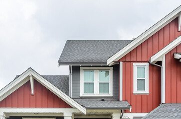 Top of luxury house with shingle roof, red and yellow trees and nice windows in Summer in...