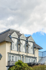 Top of luxury house with shingle roof, red and yellow trees and nice windows in Summer in Vancouver, Canada, North America. Day time on June 2024.
