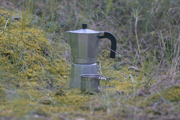 Aluminum coffee maker with aluminum cup in a forest, camping