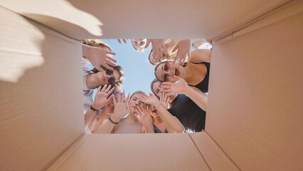 Group of high school students enthusiastically exploring the surprises hidden in a cardboard box...