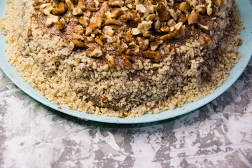 Delicious homemade cake with meringue, peanuts and walnuts on a light background. Concept of natural homemade baking