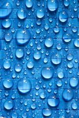 Water rain droplets on blue industrial waterproof tarpaulin sheet background backdrop. Industrial commercial heavy duty material