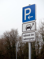 Parkplatzschild mit Zusatzzeichen: Fahrzeuge mit E-Kennzeichen, während des Ladevorgangs - Beschilderung Parkplatz mit Ladesäule für Elektrofahrzeuge