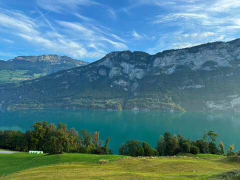 Walensee sparkling under cirrus clouds and surrounded by mountains in switzerland