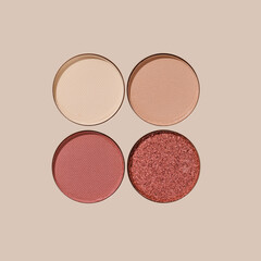 Set of colorful Swatches eyeshadow refills. Close-up of matte and glitter round pans red brown shade on beige background with sun shadows, detailed texture, cosmetic, beauty product, makeup