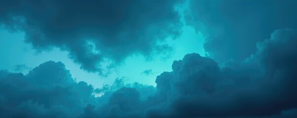 Swirling blue and teal clouds in a darkened sky, abstract, cloudy, atmospheric