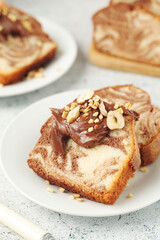 A piece of marble biscuit with chocolate cream and nuts	