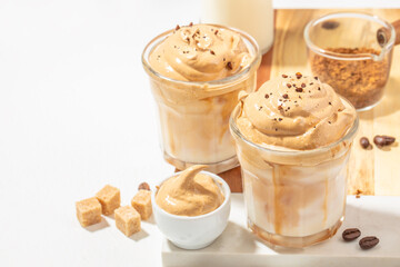 Dalgona coffee. Iced fluffy creamy whipped trend drink with coffee foam and milk. on a light background, top view. copy space