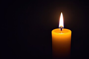 Single candle flame in dark