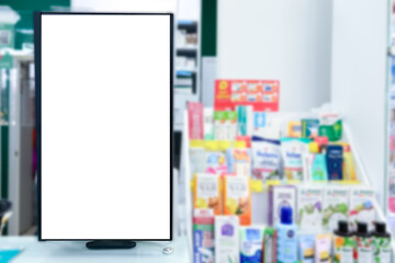 Pharmacy store. Blank empty white display panel advertising sign against blurred shelves in medical...