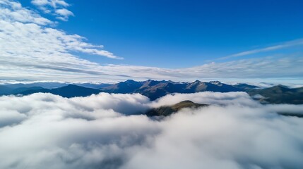 Fototapeta premium Aerial view of mountainous landscape covered in clouds under a bright blue sky : Generative AI