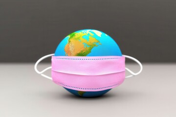 A globe covered by a medical mask representing global health issues and safety awareness.