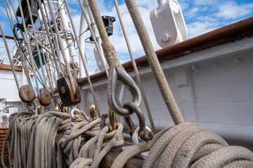 Obraz premium A boat has many ropes hanging from it. The ropes are white and are tied to the boat