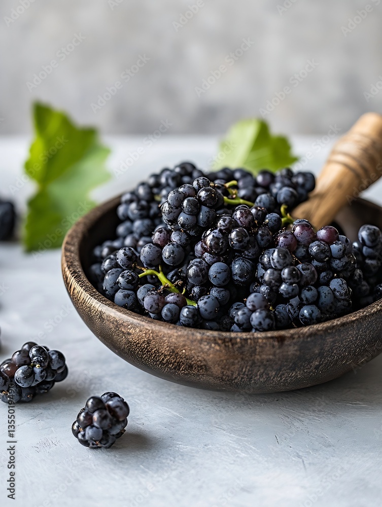 Poster fresh black grapes in a rustic wooden bowl surrounded by greenery on a muted background : generative