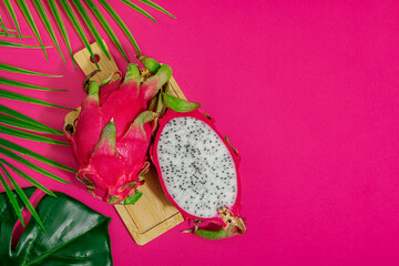 Fresh pitahaya on bright pink background. Dragon fruit harvest, tropical product