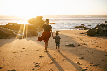 Mother and son on the ocean shore at sunset. Mother's love for her child