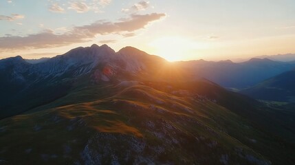 Breathtaking sunset over rolling hills with mountain peaks illuminated by golden light : Generative AI