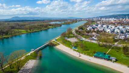 Aerial drone view of Park Jarun in Zagreb, showcasing stunning blue water, lush greenery, and the nearby Sava River Park features excellent bicycle roads, perfect for cycling and outdoor activities