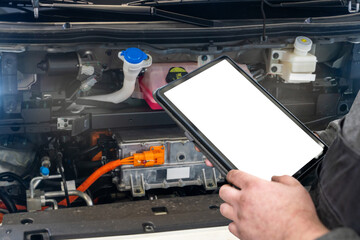 Serviceman with digital tablet next to electric car with open hood. Electric vehicles maintenance