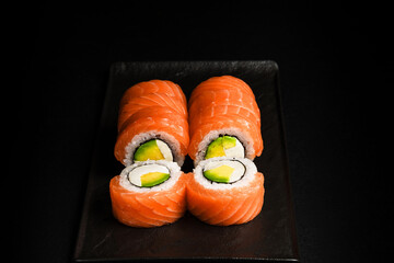 Delicious Fresh Salmon Sushi Rolls Presenting Exquisitely on a Black Background