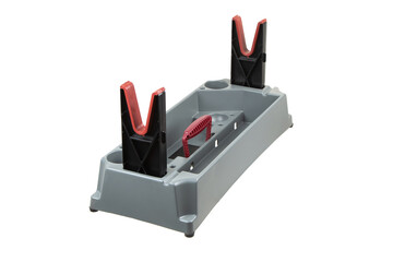 A versatile gun cleaning tool with a gray plastic base, integrated compartments, red and black V-shaped holders, and a functional red handle.