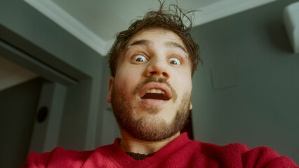 Close-up of a bearded man smiling during a video conference call in a well-lit indoor setting