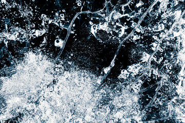Ice texture background. The textured cold frosty surface of the ice on a black background.