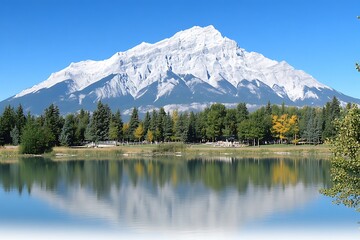 Majestic mountain reflecting on calm water beside green trees