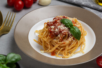 Pasta Penne Bolognese in white plate on light background. Bolognese sauce is classic Italian cuisine dish. Popular Italian food.