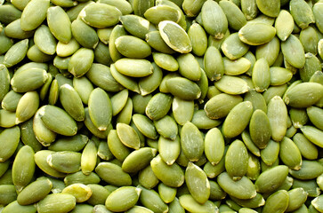 Ripe, green pumpkin seeds background, texture, top view. Pumpkin seeds close-up, background, texture, top view. Green pumpkin seeds as background.