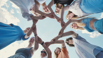 School friends come together in a circle, showcasing unity, teamwork, and collaboration under a clear sky