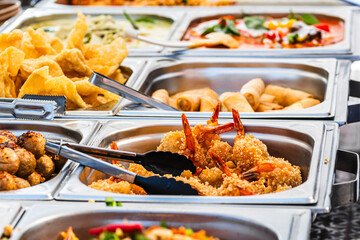 Various Thai dishes at a street food stand, focus on fried shrimps