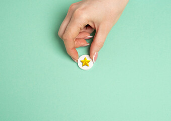 The hand holds a gold star. Distinction. Rating and recognition. Achievement. Top ratings in professional or educational settings.