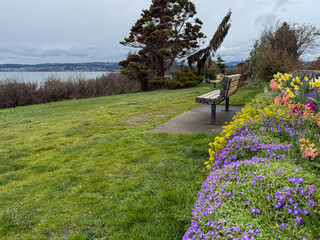 Spring flowers and an empty bench at a waterfront park