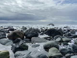 Large rocks and breaking waves on the Pacific Northwest Coast on a cloudy day