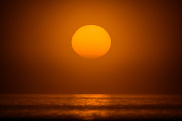 Sunrise through the fog with orange sun