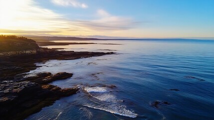 Obraz premium Breathtaking aerial view of a serene ocean landscape at sunset with calm water and rocky shorelines : Generative AI