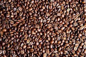 A cup of coffee with roasted coffee beans.