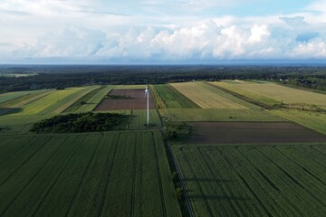 wind turbine is standing in a rural landscape, generating clean energy for a nearby village