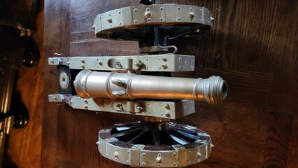 Two antique cannons are positioned on a patterned floor within a vintage room featuring detailed...