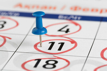 11th calendar date is marked with blue button. Closeup.