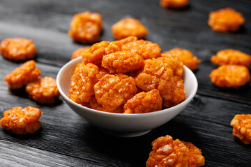 Spicy chilli rice crackers in white bowl. Party food snacks